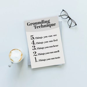 May include: A white card with the text "Grounding Technique" and a list of five things you can use to ground yourself: see, feel, hear, smell, and taste.