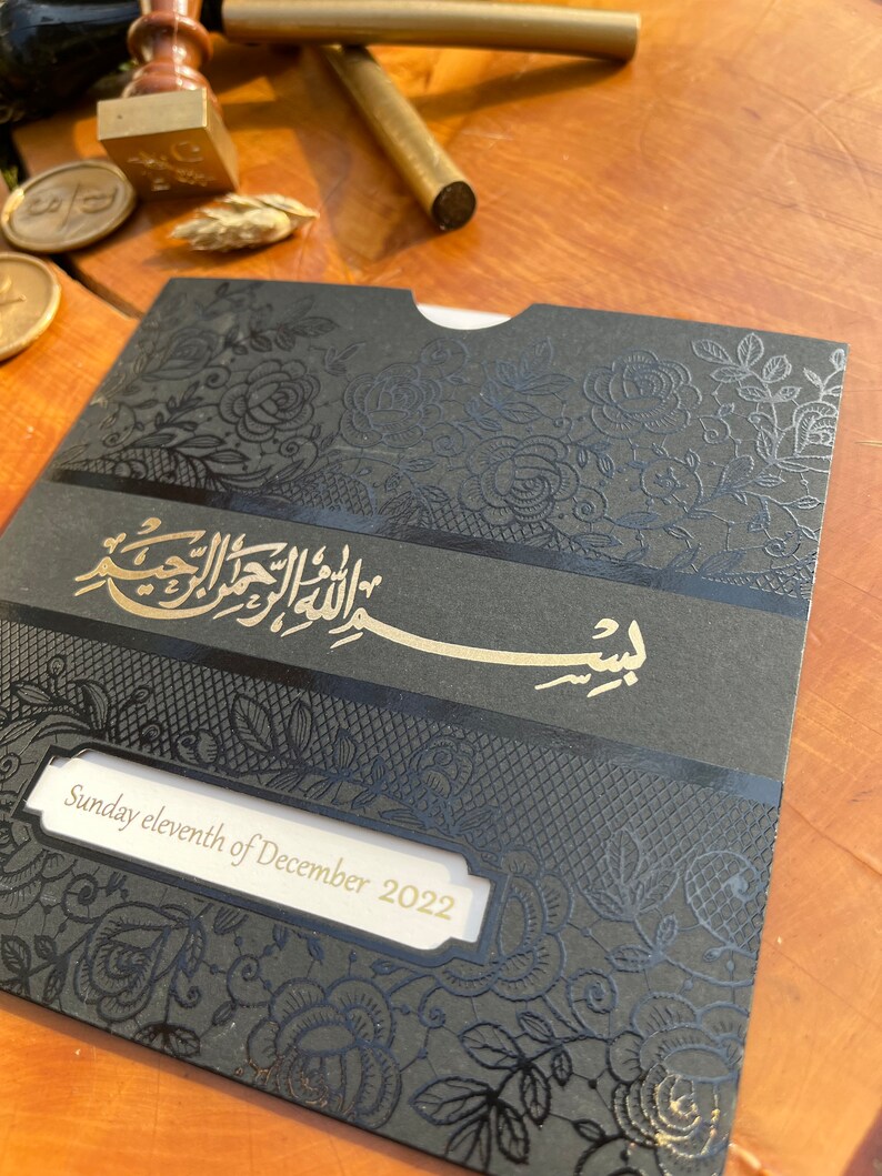 May include: A black and gold wedding invitation with a floral design and the text "Sunday eleventh of December 2022".