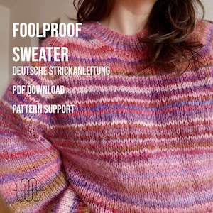 Op de afbeelding: Een gebreide trui in roze, paarse en bruine tinten. De trui heeft een ronde hals en lange mouwen. Tekst op de afbeelding luidt "FOOLPROOF SWEATER", "DEUTSCHE STRICKANLEITUNG", "PDF DOWNLOAD" en "PATTERN SUPPORT".