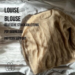 Könnte beinhalten: Ein beiger Strickpullover mit Zopfmuster. Der Pullover liegt auf einer weißen Oberfläche. Der Text "LOUISE BLOUSE" ist oben im Bild in Schwarz geschrieben. Der Text "DEUTSCHE STRICKANLEITUNG" ist in Schwarz unter dem Titel geschrieben. Der Text "PDF DOWNLOAD" ist in Schwarz unter der ersten Textzeile geschrieben. Der Text "PATTERN SUPPORT" ist in Schwarz unter der zweiten Textzeile geschrieben.