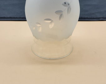May include: A frosted glass lampshade with a delicate floral design. The shade is white and has a clear glass base.