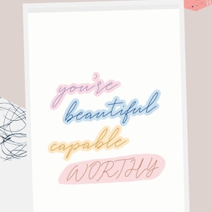 Op de afbeelding: Gratis printbare wandkunst met een roze, blauwe en gele kleurschema. De tekst luidt "you're beautiful capable worthy".