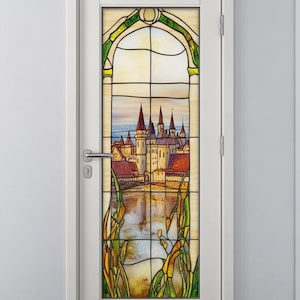May include: A stained glass window depicting a castle with a river in the foreground. The castle is made of stone and has a tall tower. The river is blue and has green reeds growing along the banks. The window is framed in white.