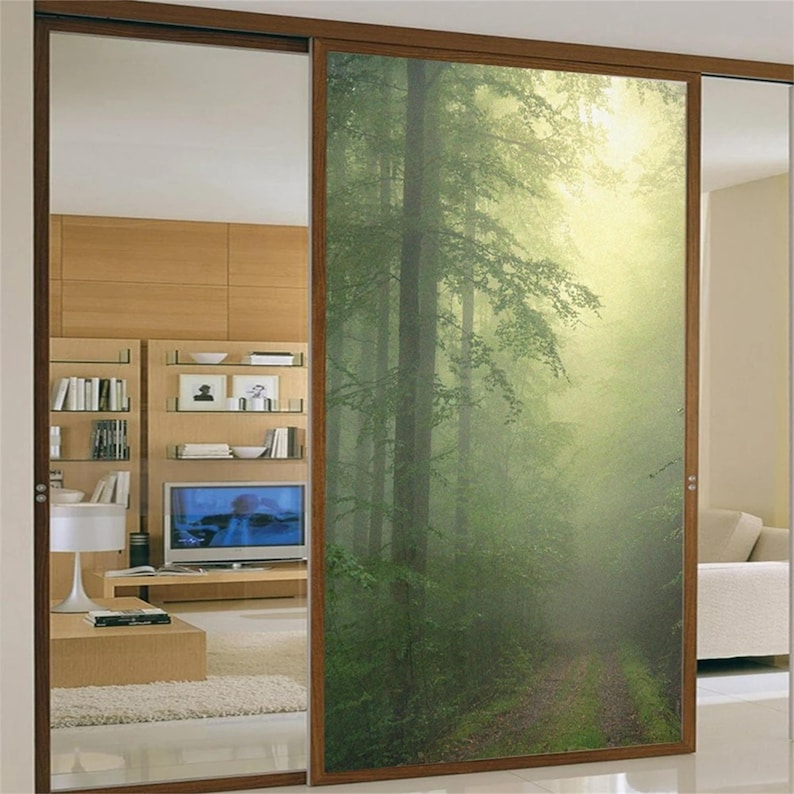 May include: A sliding glass door with a printed image of a misty forest path. The door is framed in wood and has a frosted glass panel on the left side.