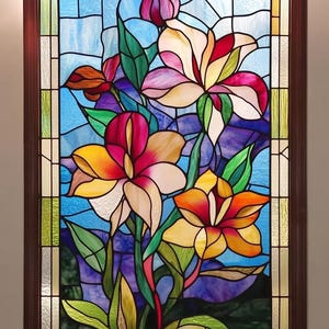 May include: A stained glass window featuring a bunch of colourful lilies with green leaves set against a blue background. The lilies are in shades of pink, yellow, orange, and red.