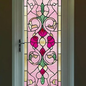 Könnte beinhalten: Eine weiße Tür mit einem Buntglasfenster, das ein rosafarbenes und grünes Blumenmuster zeigt. Das Muster enthält eine Diamantform in der Mitte und eine rosa Blume auf jeder Seite.