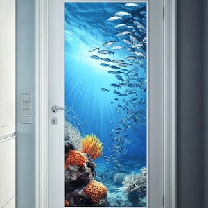May include: A door decal depicting a lively underwater scene with a shoal of silver fish swimming towards a bright light source. The background is a deep blue ocean with coral reefs and orange sponges.