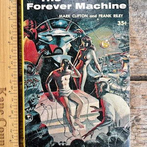 Puede incluir: Libro de bolsillo vintage titulado "The Forever Machine" con una ilustración de ciencia ficción. La portada presenta una escena futurista con robots, figuras y el texto "MARK CLIFTON and FRANK RILEY". El libro mide unos 18 cm de alto.