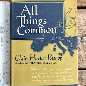 Puede incluir: Un libro amarillo y azul titulado "All Things Common" de Claire Huchet Bishop, autora de "France Alive". La portada del libro presenta un mapa de Europa y el texto "Where in Western Europe independent groups of workers' families of different faiths and ideologies are building together a new way of living". El libro fue publicado por Harper & Brothers y establecido en 1817.