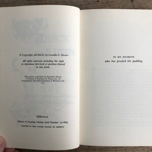 May include: A vintage cookbook titled "Quick and Easy Meals for Two" by Louella G. Shouer. The book cover is yellow with a red and white illustration of a rooster. The copyright date is 1952.