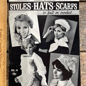 Può includere: Copertina di rivista vintage in bianco e nero con donne che indossano stole, cappelli e sciarpe lavorati a maglia o all'uncinetto. La copertina include il testo "STOLES HATS SCARFS...to knit or crochet..." e "VOL. 14 75¢".
