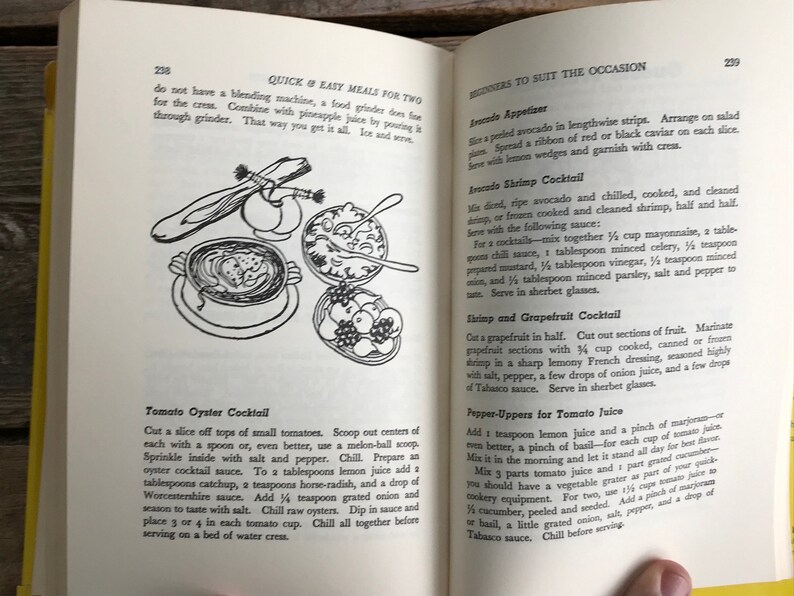 May include: A vintage cookbook page with illustrations of tomato oyster cocktail, shrimp and grapefruit cocktail, and avocado shrimp cocktail. The page includes recipes for each cocktail.