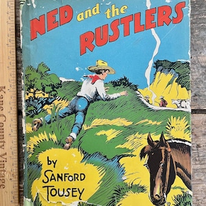 May include: Vintage children's book titled "Ned and the Rustlers" by Sanford Tousey. The cover features a colorful illustration of a cowboy running across a grassy hill, with a horse in the foreground and a blue sky background.