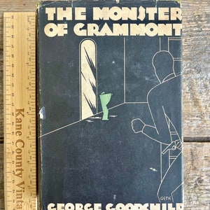 May include: A vintage paperback book titled "The Monster of Gramont" by George Goodchild. The cover features a black and white illustration of a person running away from a room with a mirror and a green object.