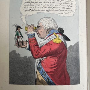 Puede incluir: Una caricatura colorida que representa a Jorge III mirando a Napoleón en miniatura a través de un telescopio. Jorge III viste una chaqueta roja con detalles dorados y azules. El texto dice "GEORGE III, AND BONAPARTE as The King of Brobdignag and Gulliver."