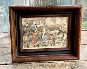 Puede incluir: Una impresión enmarcada que representa una escena histórica con figuras, un carruaje tirado por caballos y edificios. El marco es de madera marrón oscuro y negra. La obra de arte presenta colores apagados e ilustraciones detalladas de personas con ropa de época.