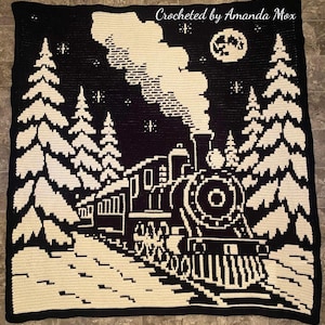 May include: A black and cream crocheted blanket featuring a steam train traveling through a snowy forest. The design includes tall pine trees, a full moon, and stars in the night sky. The text Crocheted by Amanda Mox is visible at the top.