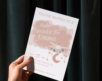 May include: A baby sprinkle invitation card with the text "YOU'RE INVITED TO A Baby Sprinkle for Emma". The card features a mobile illustration with stars and a crescent moon. The date is May 17, 2025, with an address and phone number.