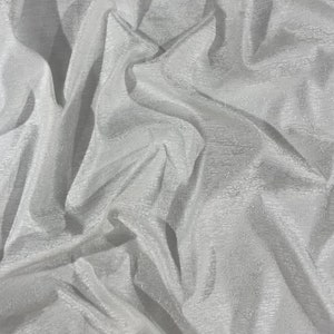 Pode incluir: Tecido branco transparente com uma superfície texturizada. O tecido está enrugado e dobrado.