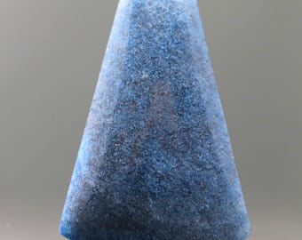 May include: A blue, cone-shaped object with a textured surface. The object has a rounded base and tapers to a narrower top. The color is a mix of dark and light blues, with a speckled appearance. The object is likely a decorative item or a component of a larger piece.