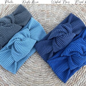 Pu&ograve; includere: Quattro fasce a righe nei toni del grigio, del blu e del blu navy sono esposte su una superficie tessuta. Le fasce sono etichettate "Pewter", "Dusty Aura", "Washed Navy" e "Royal Blue". Le fasce hanno un design a nodo attorcigliato.