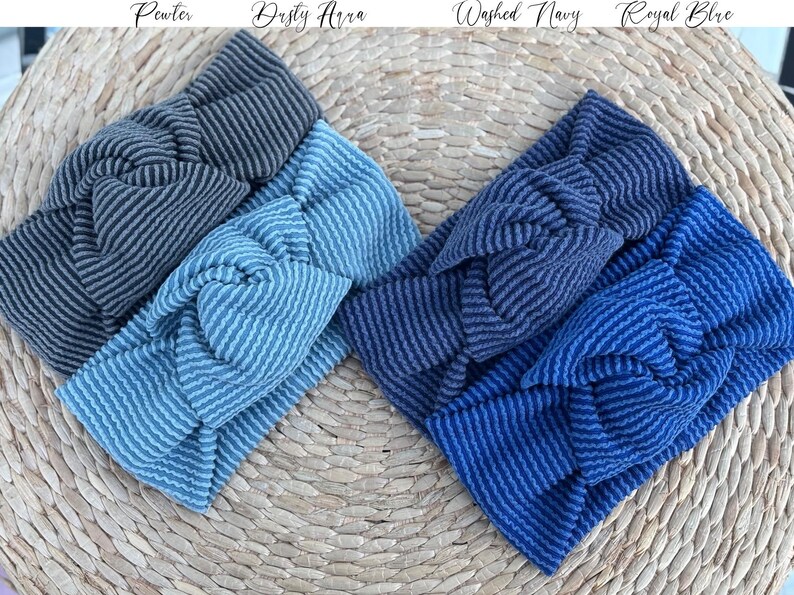 Pu&ograve; includere: Quattro fasce a righe nei toni del grigio, del blu e del blu navy sono esposte su una superficie tessuta. Le fasce sono etichettate "Pewter", "Dusty Aura", "Washed Navy" e "Royal Blue". Le fasce hanno un design a nodo attorcigliato.