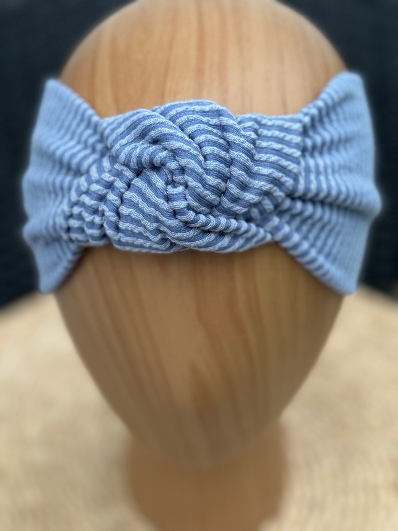 Pu&ograve; includere: Fascia per capelli a righe blu e bianche con un design annodato. La fascia &egrave; realizzata in un tessuto a coste morbido ed &egrave; progettata per essere indossata intorno alla testa. Il colore &egrave; blu chiaro con strisce bianche.