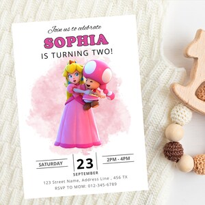 Puede incluir: Una invitaci&oacute;n de cumplea&ntilde;os rosa y blanca con una imagen de dibujos animados de la princesa Peach y Toad. La invitaci&oacute;n dice "&iexcl;&Uacute;nete a nosotros para celebrar que Sophia cumple dos a&ntilde;os!" S&aacute;bado, 23 de septiembre, 2 PM-4 PM. 123 Street Name, Address Line, 456 TX. RSVP a mam&aacute;: 012-345-6789.