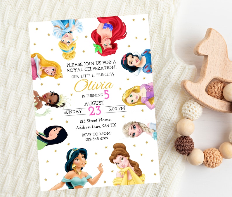 May include: A white invitation with gold stars and a pink and gold border. The invitation features a collage of Disney princesses, including Cinderella, Ariel, Snow White, Belle, Jasmine, Aurora, and Elsa. The text reads "Please join us for a Royal Celebration! Our little princess Olivia is turning 5 August 23, 3:00 PM. 123 Street Name, Address Line, 234 TX. RSVP to Mom: 012-345-6789."