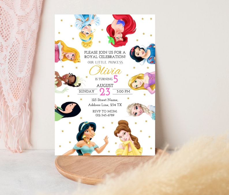 May include: A white invitation with gold stars and a pink and white border. The invitation features a collage of Disney princesses, including Cinderella, Ariel, Snow White, Tiana, Rapunzel, Elsa, Jasmine, and Belle. The text reads "Please join us for a Royal Celebration! Our little princess Olivia is turning 5 August 23, 3:00 PM. 123 Street Name, Address Line, 234 TX. RSVP to Mom 012-345-6789."