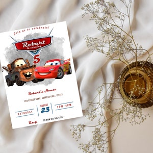 May include: A white invitation card featuring the characters Mater and Lightning McQueen from the movie Cars. The invitation includes the text "Robert is turning 5" and event details. The card is decorated with a watercolor-style background.