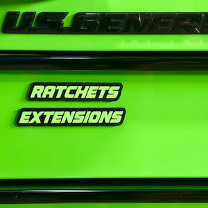 May include: Bright green tool chest with black accents. The words "US GENERAL" are across the top. Below are the words "RATCHETS" and "EXTENSIONS" in a green font with a black border.