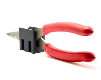 May include: A pair of red-handled pliers with a black plastic base. The pliers are in a closed position.