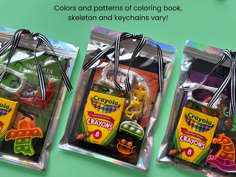 Puede incluir: Tres bolsas hologr&aacute;ficas que contienen sets de actividades de Halloween. Cada set incluye una caja de 8 crayones Crayola, un peque&ntilde;o esqueleto de pl&aacute;stico, un marco de pl&aacute;stico blanco y un juguete fidget de silicona, atados con una cinta a rayas.