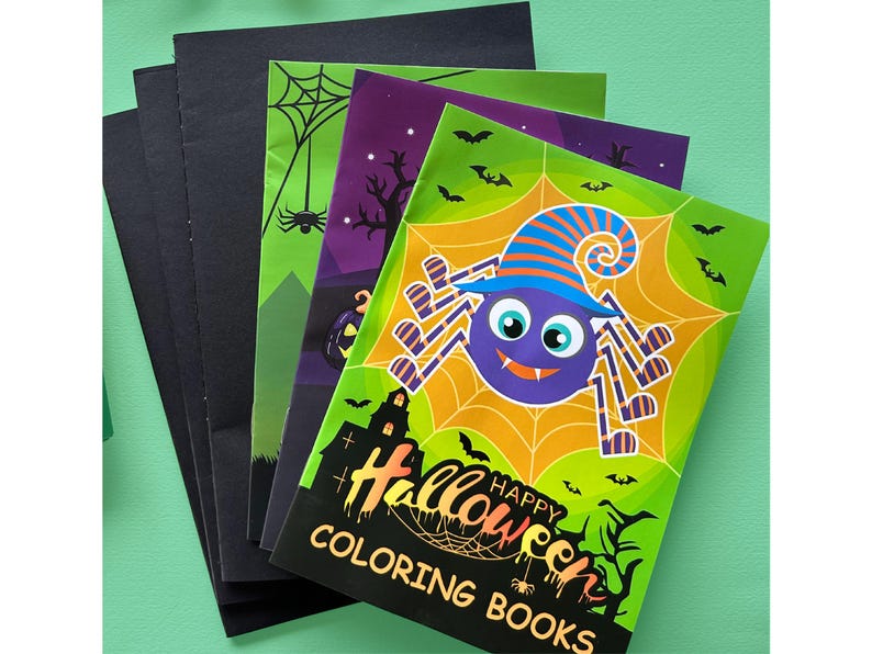 Puede incluir: Una pila de libros para colorear de Halloween con una ara&ntilde;a morada que lleva un sombrero de bruja a rayas azules y naranjas sobre una telara&ntilde;a amarilla. La portada muestra una silueta de casa encantada negra, murci&eacute;lagos y el texto HAPPY HALLOWEEN COLORING BOOKS.