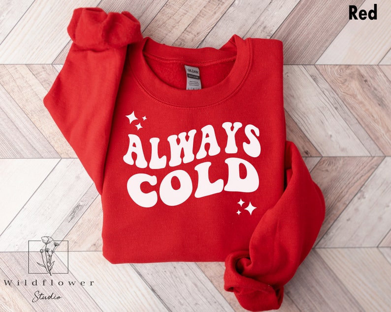May include: Red sweatshirt with the text "ALWAYS COLD" in white retro font.