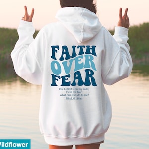 K&ouml;nnte beinhalten: Wei&szlig;er Kapuzenpullover mit dem Text "FAITH OVER FEAR" in Blau und Hellblau. Darunter steht das Zitat "The LORD is on my side; I will not fear: what can man do to me? PSALM 118:6".