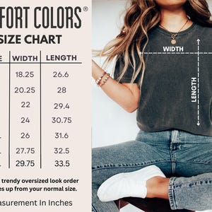 May include: A size chart for Comfort Colors t-shirts is displayed, showing measurements in inches. The chart includes sizes S to 4XL, with width and length dimensions. A person is wearing a dark gray t-shirt, with width and length indicators.
