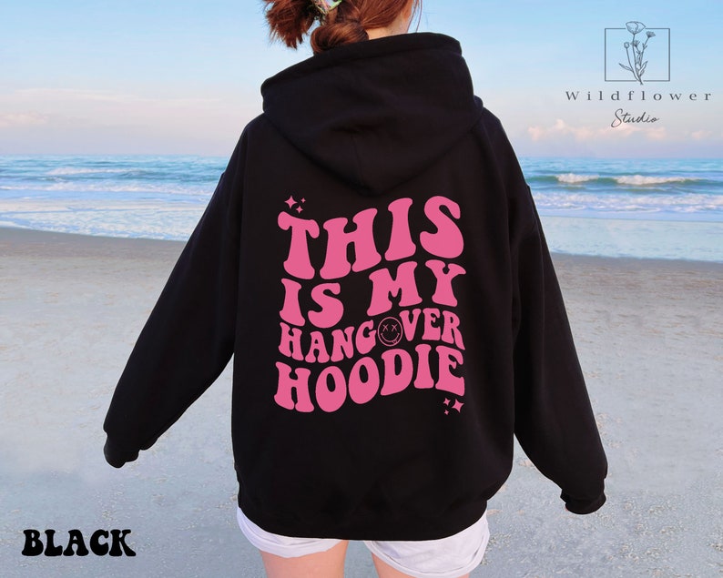 May include: Black hoodie with a pink graphic that says "This is my hangover hoodie" with a smiley face in the word hangover.