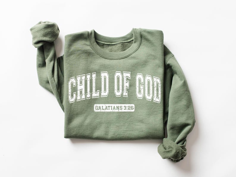 May include: A green sweatshirt with the text "CHILD OF GOD" in white lettering and "GALATIANS 3:26" in smaller white lettering below.