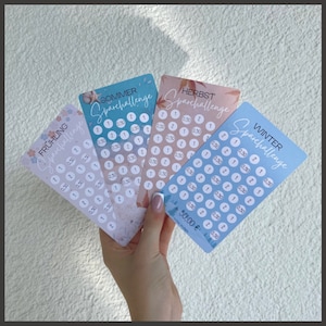 May include: Four colorful cards with a light blue background and white circles. Each card has a different season name: Spring, Summer, Fall, and Winter. The cards have the text "Sparchallenge" and a price amount in Euros.