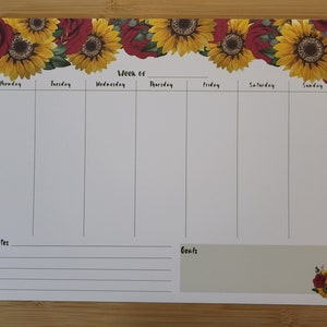 Peut inclure: Un planificateur hebdomadaire avec une bordure florale de tournesols et de roses rouges. Le planificateur comporte des sections pour chaque jour de la semaine, du lundi au dimanche, ainsi que des sections pour les notes et les objectifs.