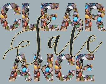 May include: A gray background with the words "CLEARANCE SALE" in large letters. The letters are filled with colorful stones. The word "Sale" is in a cursive font, overlaying the word "Clearance".