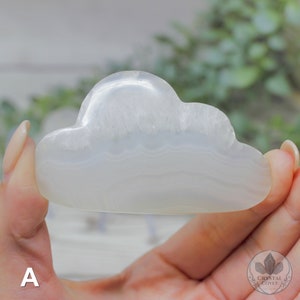 May include: White agate cloud-shaped crystal with a smooth, polished surface. The crystal has a cloudy, translucent appearance with subtle white and gray banding.