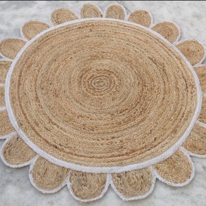 May include: A round jute rug with a white border and a flower-shaped design. The rug is made of natural fibers and has a rustic look.