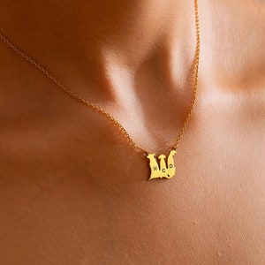 Könnte beinhalten: Goldkette mit einem Anhänger, der drei Erdmännchen mit den Buchstaben H, C und D im Inneren zeigt.