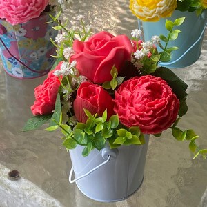 Soap roses, peonies, and tulips in an arrangement of artificial Baby’s breath and greeneries.