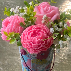 May include: A pink rose and two pink peonies in a floral patterned metal bucket with a pink handle.