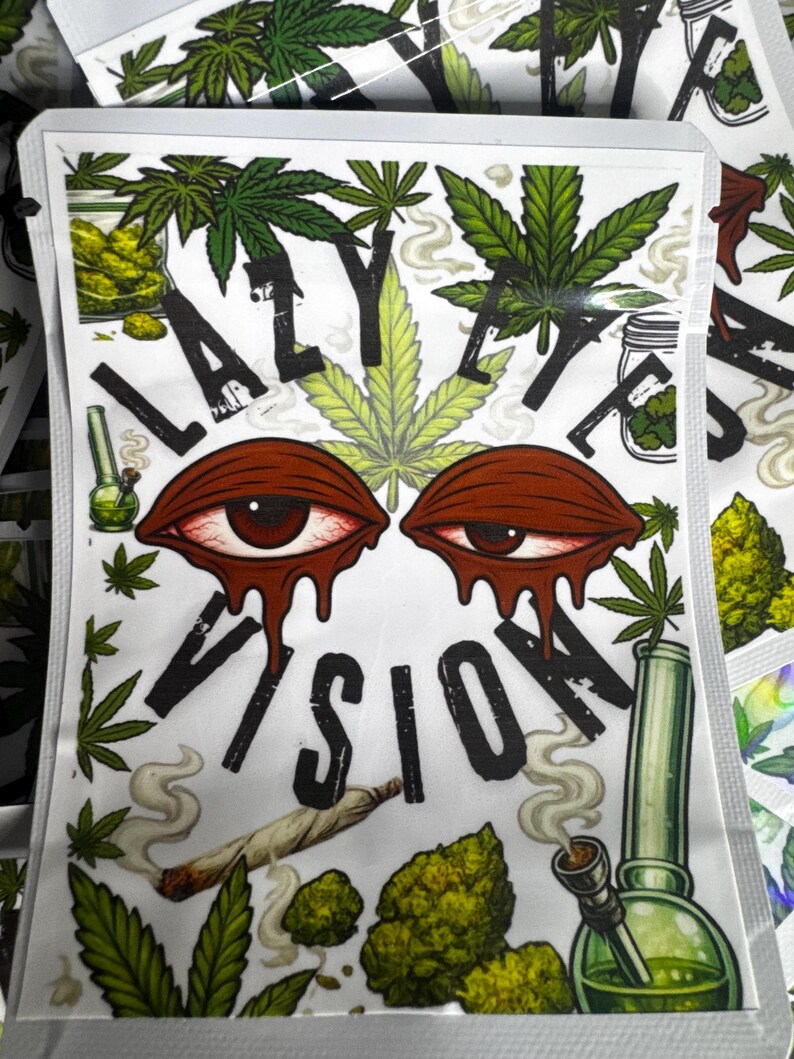May include: A rectangular white pouch featuring the text LAZY EYE VISION in black letters. The design includes two red, bloodshot, melting eyes, green cannabis leaves, a lit joint, and a green glass water pipe with swirling smoke.