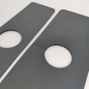 May include: Two gray cardboard pieces with cut-out circles. The pieces are designed to be joined together to create a larger shape.